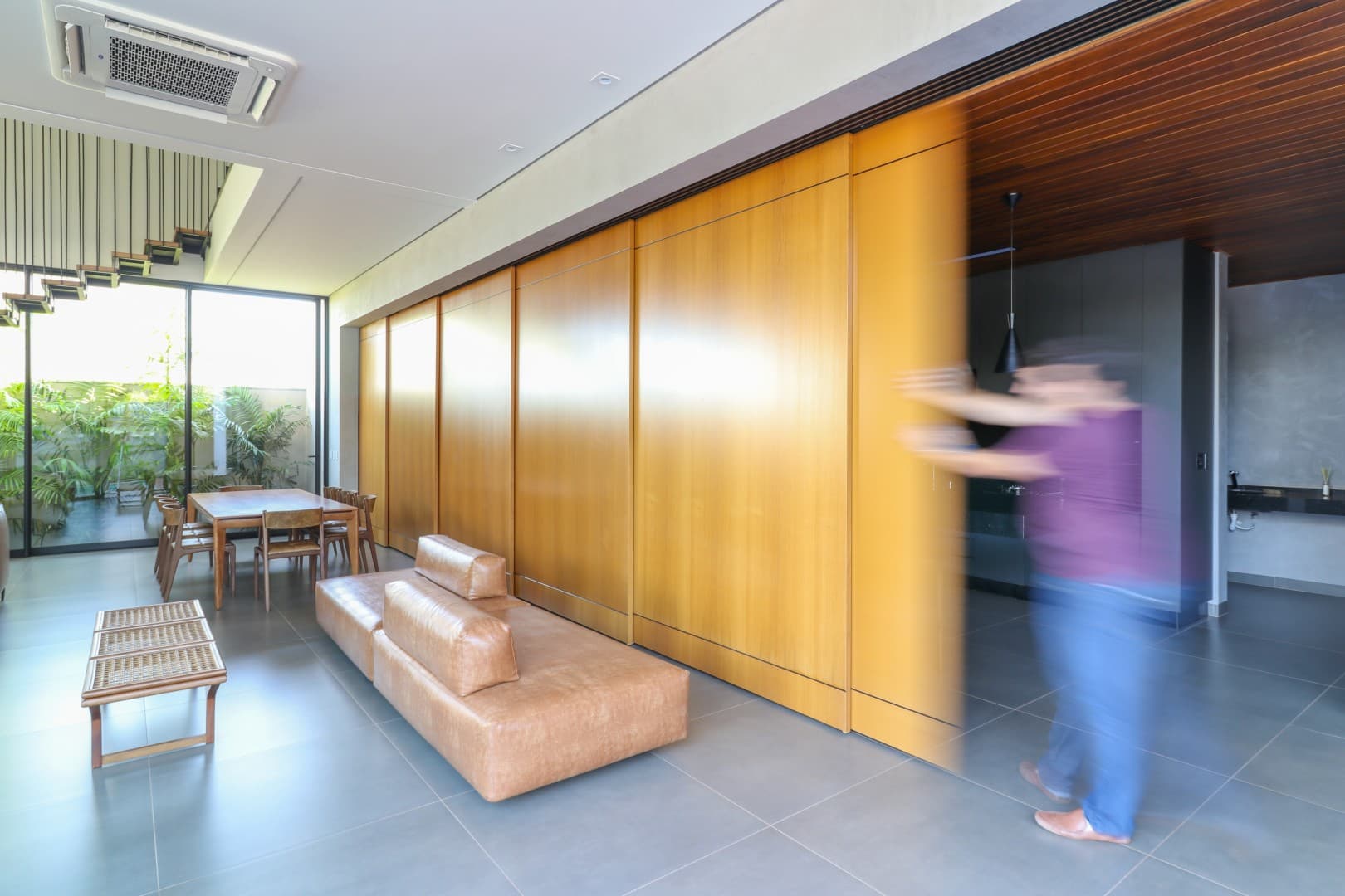 Casa CaCle – sala de jantar com mesa, cadeiras e painéis de madeira deslizantes