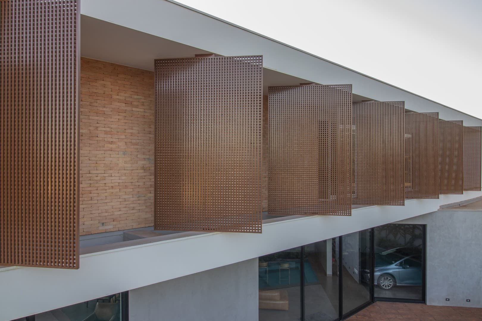 Casa CaCle – fachada com cobogós de tijolo aparente e ripas de madeira